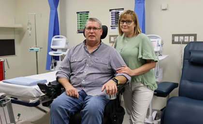 A man in a wheelchair with a woman standing beside him